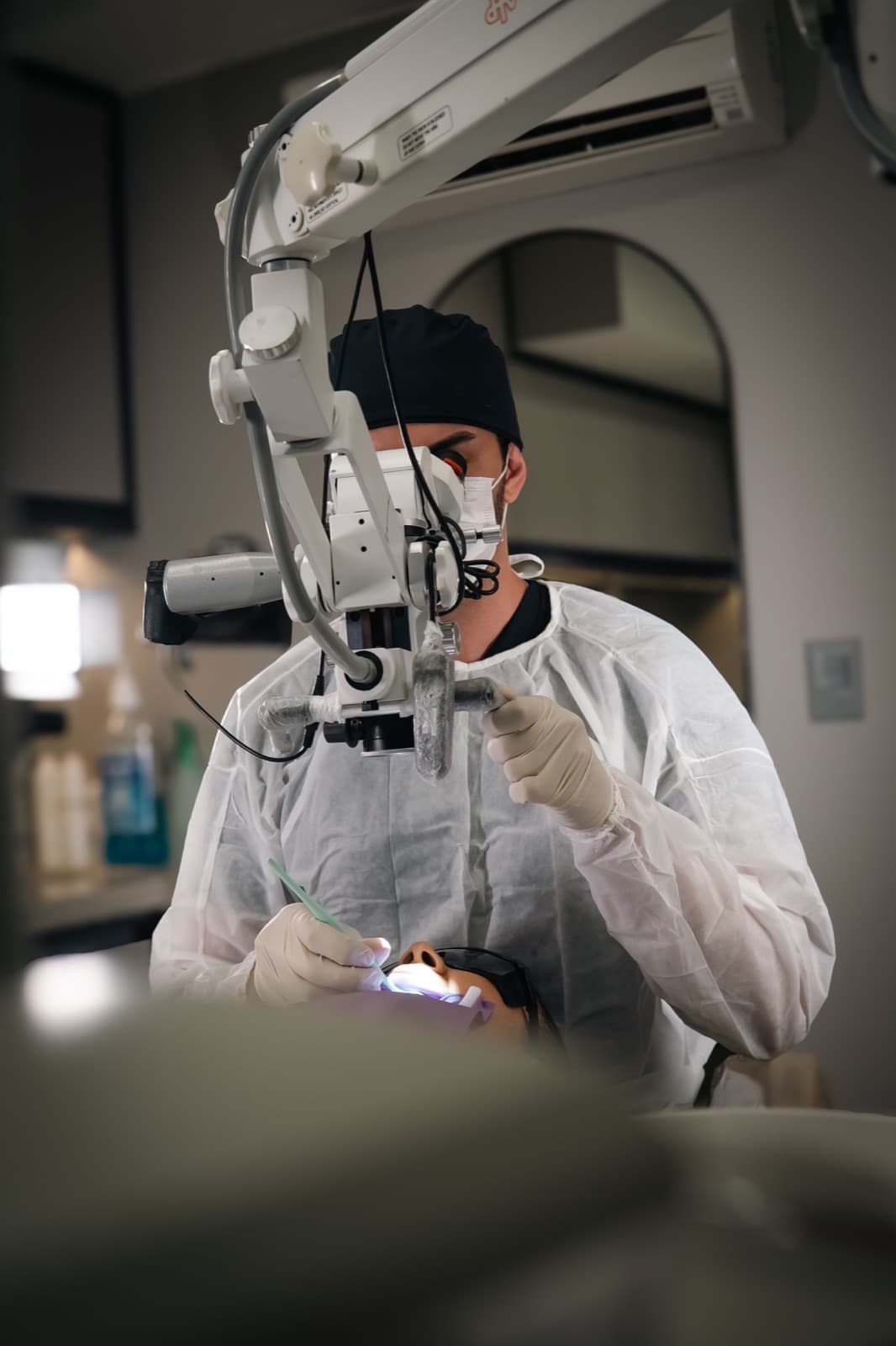 Endodontista realizando tratamento de canal com microscópio operatório