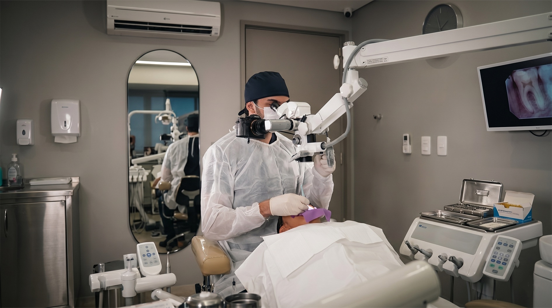 Endodontista realizando tratamento de canal com microscópio operatório